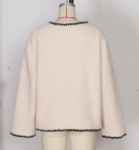 Back view of thick cream fleece coat with black contrast braided trim and straight silhouette