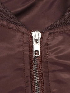 Detailed view of silver metal zipper and ribbed knit collar on dark brown flight jacket