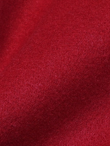 Close-up macro of premium thick red wool fabric texture for women's winter coats