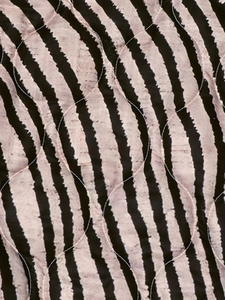 Détail du tissu matelassé avec des rayures d'animaux roses et noires pour manteau d'hiver