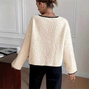 Detail view of beige fleece coat with contrast black knitted edges and back seam detail