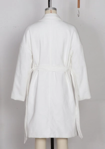 Detail view of white wool-like coat featuring a tie waist belt and drop shoulder design