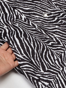 Detail of zebra print jacket showing deep side pocket and silver snap buttons