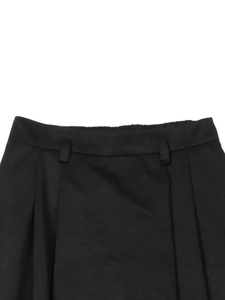 Détail d'une jupe trapèze noire à taille haute avec ceinture élastique au dos et passants
