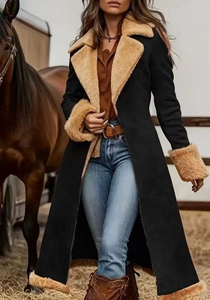 Women's long suede coat with faux fur trim in a rustic stable setting
