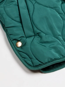 Dunkelgrüne Steppjacke mit Wellensteppmuster und elegantem goldener Metallknopf