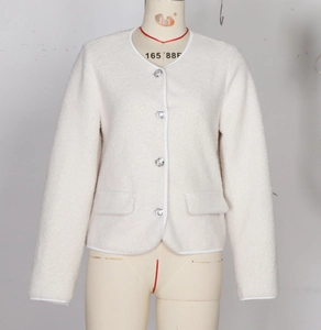 Close-up of white fleece jacket featuring silver embossed buttons and fine edge piping