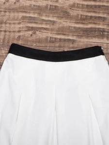 High-waisted pleated midi skirt with black wide waistband and invisible side zipper