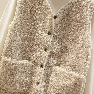 Close-up of lamb wool vest showing soft granular fleece texture and dark brown buttons