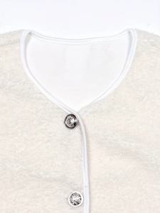 Close-up of cream fleece jacket featuring silver lion-head embossed buttons and V-neckline