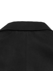 Detailed close-up of the black suit jacket collar and professional shoulder stitching