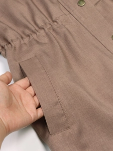 Detail of khaki jacket showing elastic drawstring waist and durable twill pocket