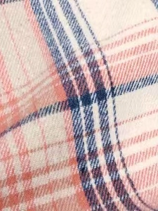Close-up of soft plaid flannel fabric with orange and navy blue checkered pattern