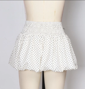 Detail view of white polka dot mini bubble skirt with elastic waist and ruffled hem