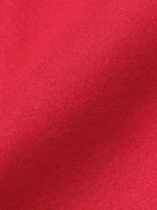 Close-up of red felt wool fabric texture showing soft fibers of the autumn jacket