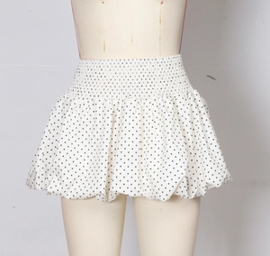 Detail of the high waist elastic smocking and polka dot pattern on the white mini skirt
