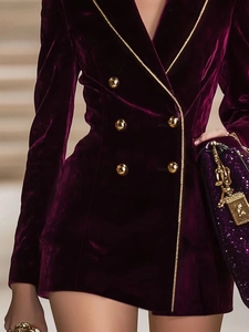 Gros plan d'un blazer en velours violet foncé avec boutons dorés à double boutonnage