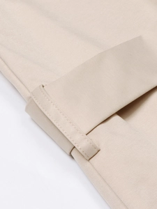 Detail van de fijne stiksels en de keperstof van de riemlus van de beige trenchcoat