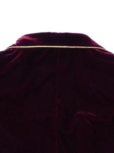Détail d'un blazer en velours luxueux avec passepoil doré élégant et texture douce