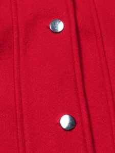 Close-up of red wool fabric texture with vertical stitching and silver metal buttons