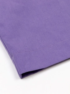 Detailed macro view of purple linen fabric showing cross-weave texture and fine stitching