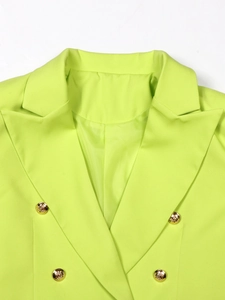 Detail of neon green blazer showing double-breasted design and gold embossed buttons