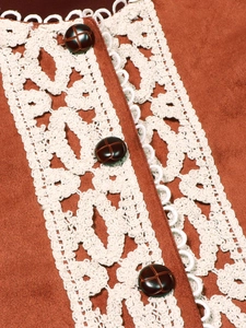 Dettaglio del gilet vintage in pelle scamosciata con pizzo e bottoni intrecciati