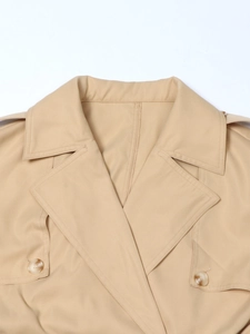 Detalle de gabardina caqui con charreteras y botones clásicos de ámbar en tejido premium