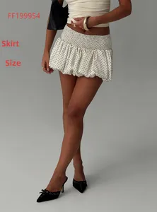 Detailed view of high-waisted white polka dot mini skirt with elastic smocked waist