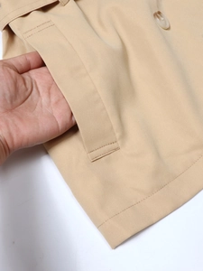 Gabardina corta caqui para mujer con botones de doble botonadura y detalle de bolsillo lateral