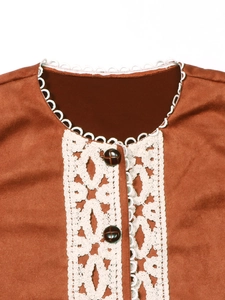 Dettaglio del gilet in pelle scamosciata marrone con pizzo bianco e bottoni vintage