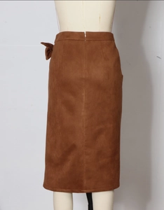 Detailed back view of a brown suede midi skirt featuring a waist bow and hidden zipper