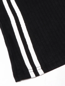 Détail du tissu en maille côtelée noire avec double rayure blanche sur l'ourlet