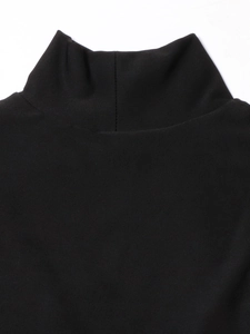 Dettaglio ravvicinato del collo alto e della trama in maglia fine sul vestito nero