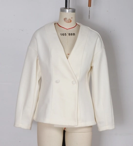 Detailed view of beige V-neck short blazer jacket with two buttons and lapel collar