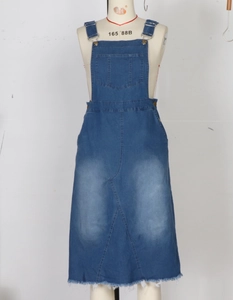 Close-up of blue denim overall skirt with metal buckles and raw hem detail