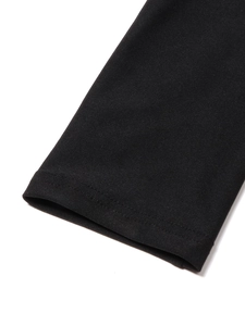 Dettaglio della manica del vestito nero in maglia con orlo rinforzato a doppia cucitura