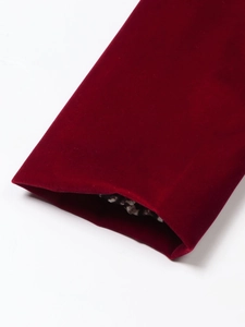 Detail of burgundy velvet suit cuff with premium leopard print lining and luxury texture