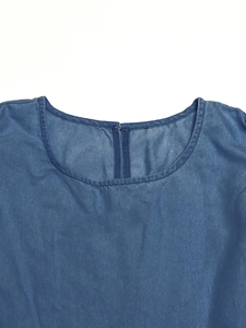 Close-up of the round neckline and zipper detail on this blue denim dress