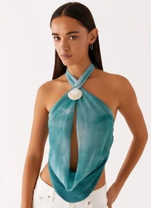 Détail du haut à col licou avec coquillage décoratif et motif tie-dye bleu-vert