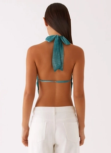 Détail du haut dos nu sarcelle avec un grand nœud papillon et un design ouvert