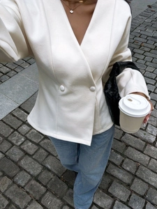 Minimalist cream double-breasted blazer top and blue jeans in street style fashion
