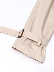Détail de la manche d'un trench beige avec boucle réglable et coutures précises