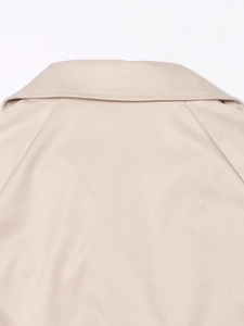 Détail d'un trench-coat beige montrant les coutures du col arrière et le tissu en coton