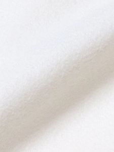 Close-up of white minimalist blazer fabric showing soft fluffy fiber texture and material