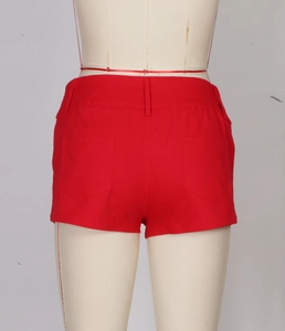 Detailed back view of red suede shorts featuring rivet accents and symmetric rear pockets
