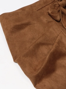 Detailed macro view of dark brown suede skirt featuring an elegant waist tie knot detail