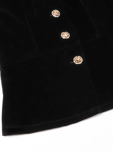 Detail of black velvet fabric featuring three vintage gold embossed buttons and stitching