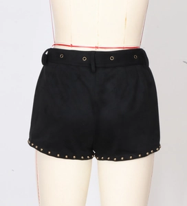 Nahaufnahme schwarzer Shorts mit Metallösen und goldener Nietendekoration am Saum