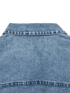 Close-up of double-needle stitching on the collar of a washed blue denim jacket